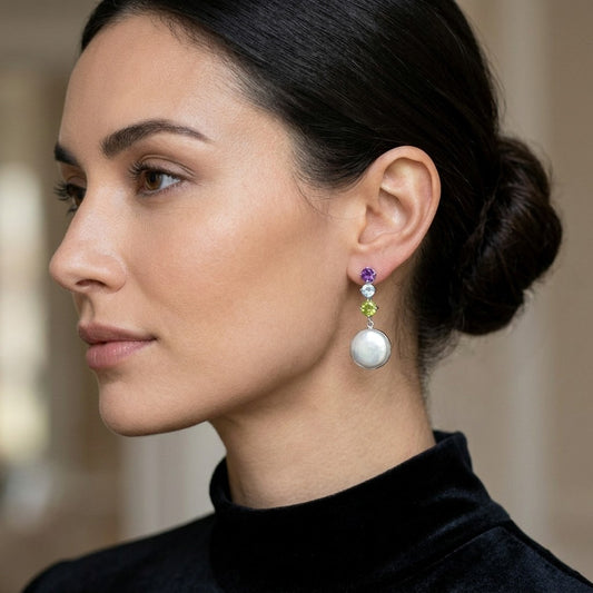 Close-up of a brunette model wearing pearl earrings with semiprecious stones