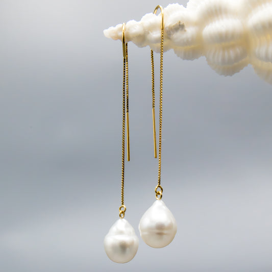 Close-up of baroque white South Sea pearl on 14K gold threader earring showing natural luster