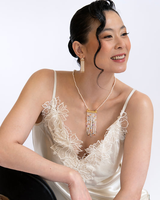 Model wearing Holly Zhang 18k yellow gold Keshi freshwater pearl woven dangle earrings with diamond drops