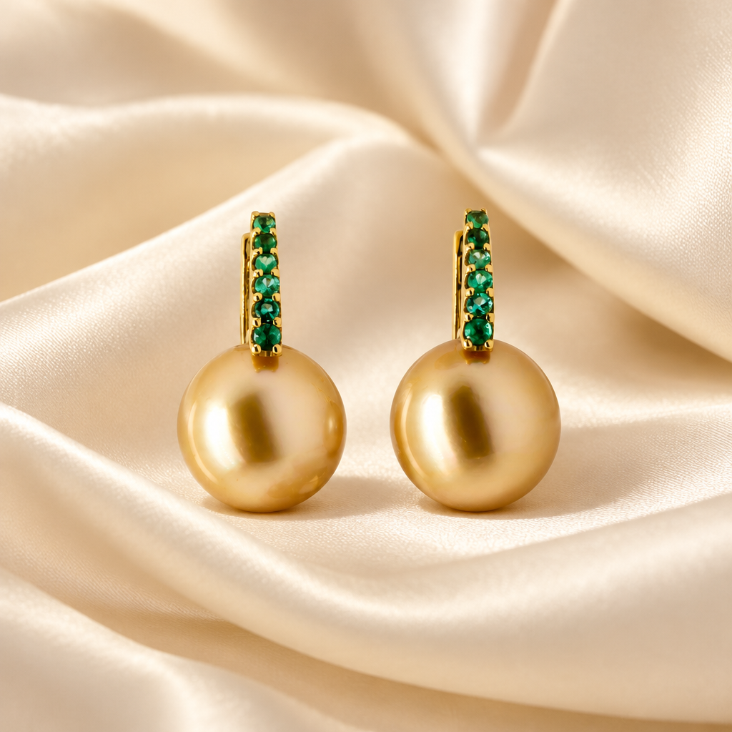 Golden South Sea Pearl & Emerald Drop Earrings in 18K Yellow Gold – Side by Side on a cream color satin background
