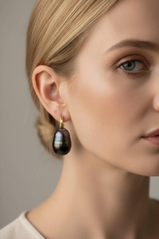 Model wearing 12.7mm baroque Tahitian pearl earrings with 14K yellow gold French hooks