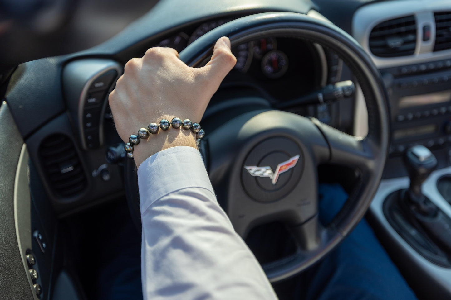 Hand on steering wheel of a Corvette car