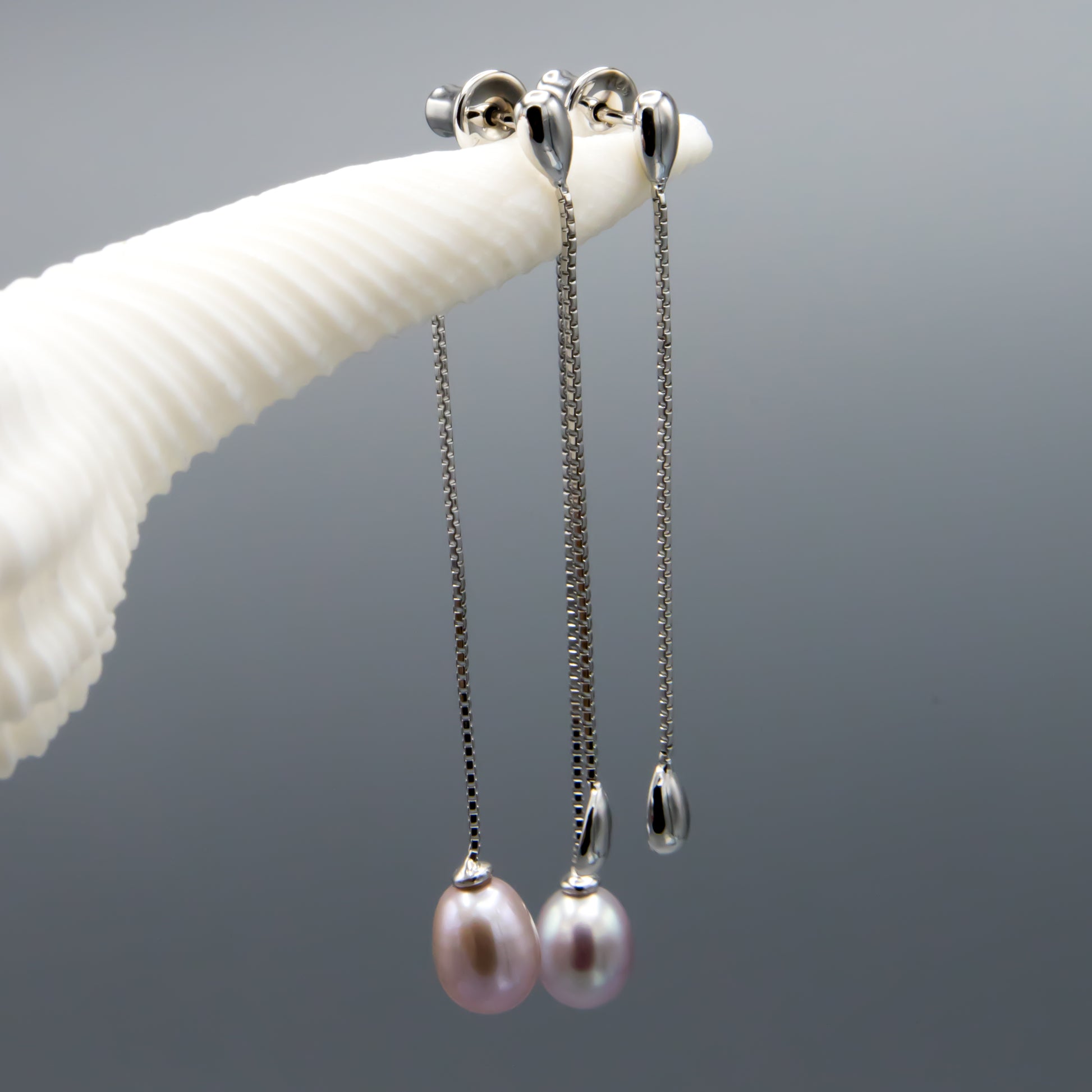 Mauve pearl earring jackets worn, showing elegant dangle and natural luster