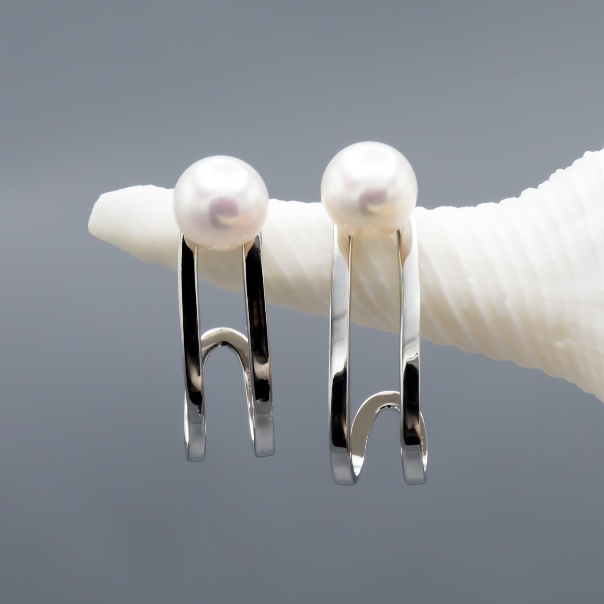 White button pearl earrings, close-up showing natural luster and sterling silver