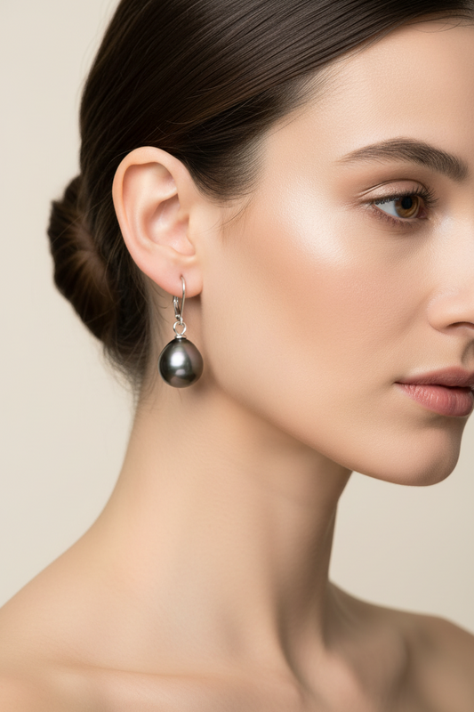 Tahitian pearl teardrop earrings in 14K white gold with secure lever back closures on brunette model