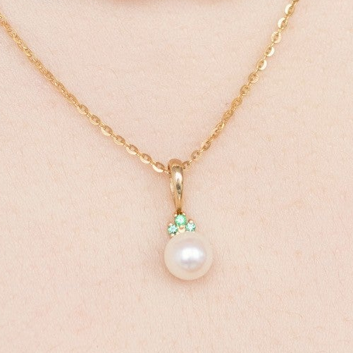 Akoya pearl and emerald pendant closeup, 14K yellow gold bail with 3 emeralds