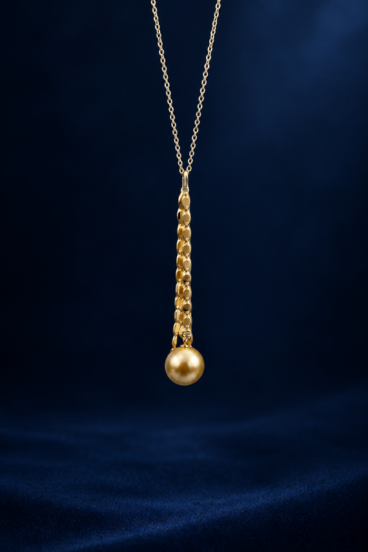 Gold necklace with a single gold south sea saltwater pearl pendant on a blue velvet background