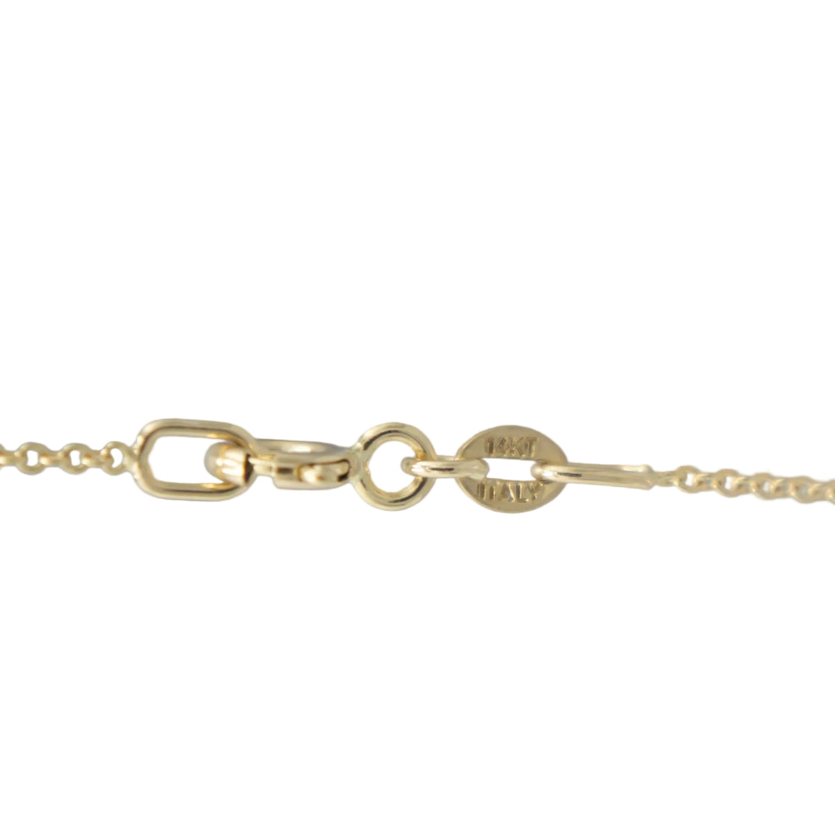 Close-up of a gold chain necklace clasp and tag on a plain white background.