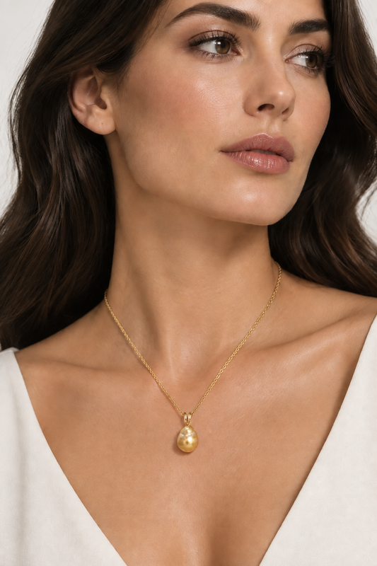 A woman wearing Golden South Sea baroque pearl pendant necklace worn on an 18-inch 14K gold chain.