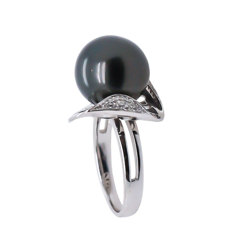 18K white gold ring with a black pearl and diamond accents on a white background