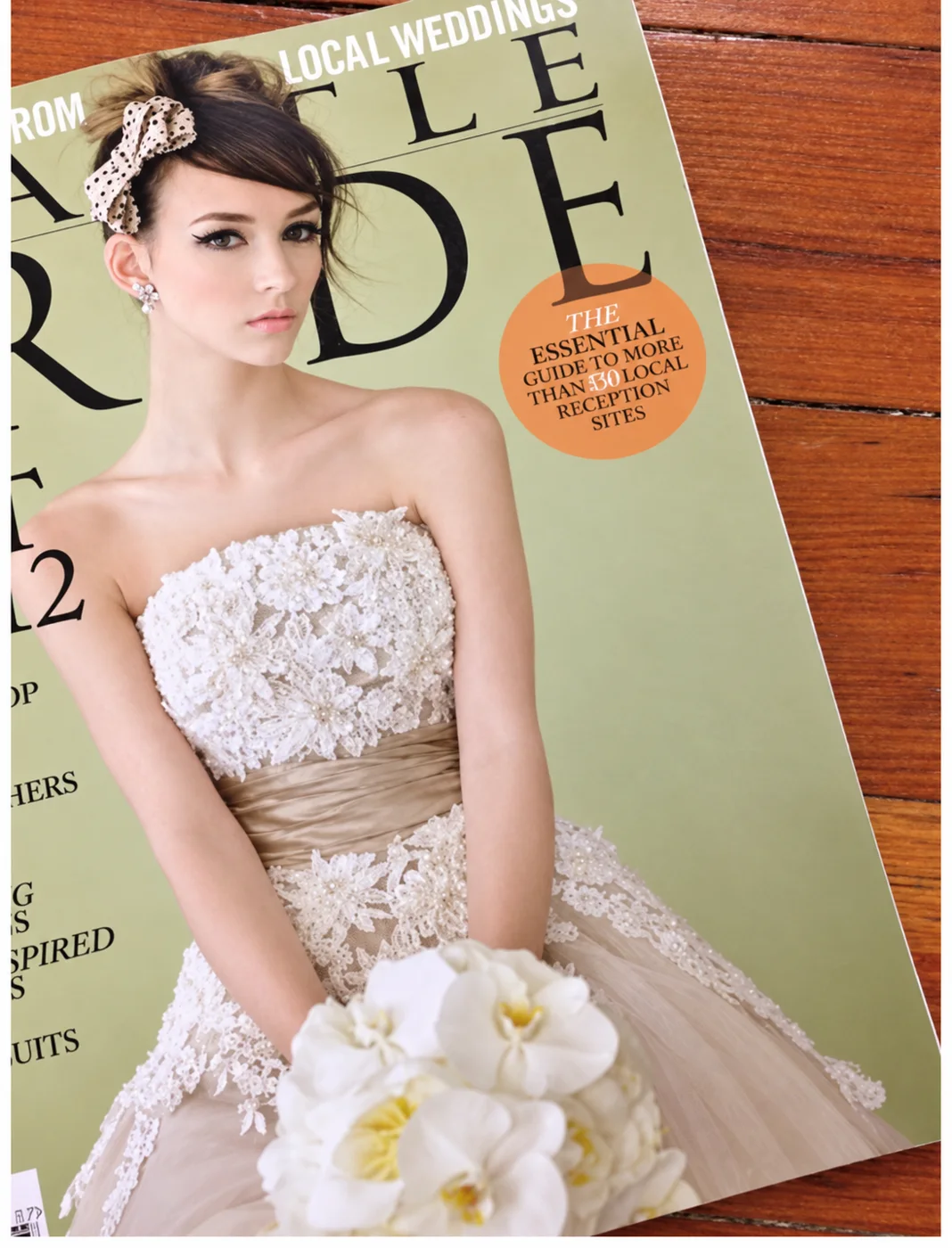 A Seattle Bride magazine cover: a bride in a lace gown with pearl earrings, holding a bouquet of white orchids