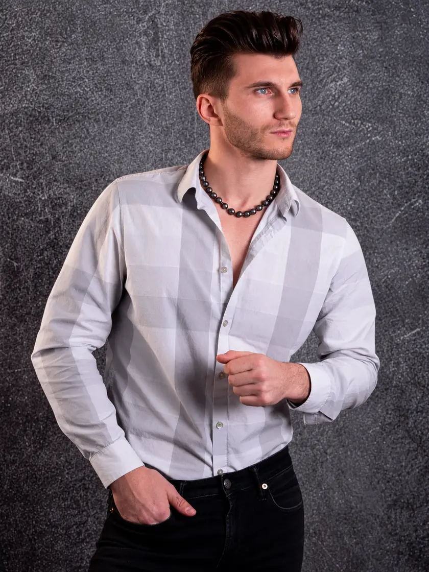 A man in a gray check shirt wearing a Tahitian pearl strand